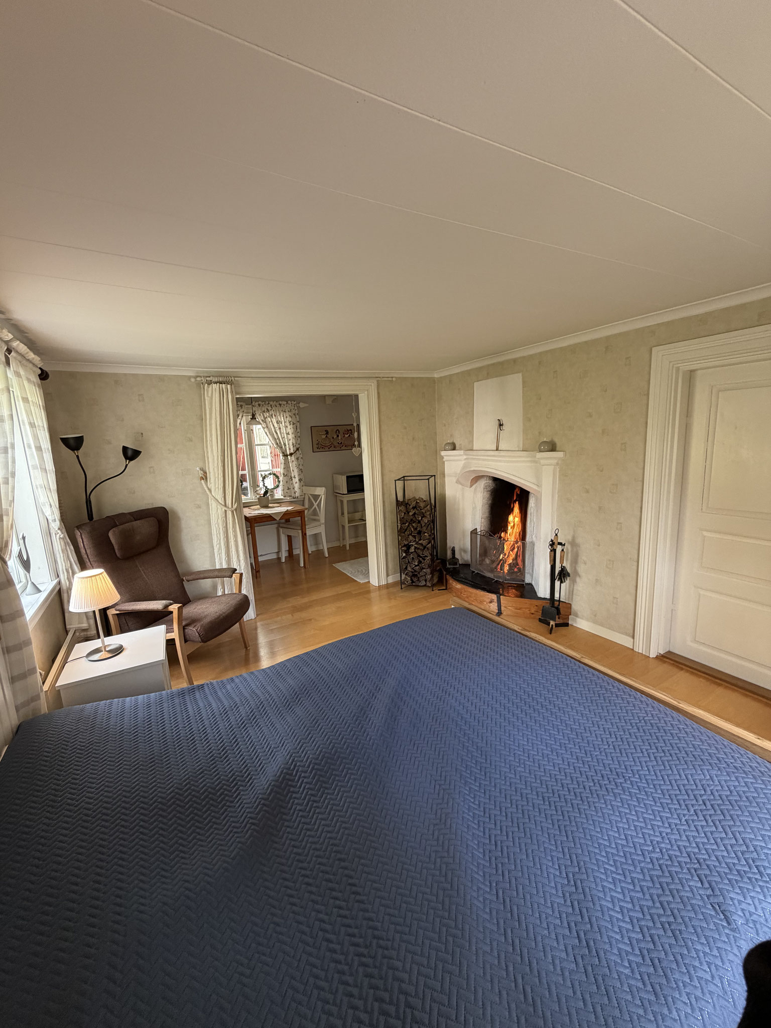 Schlafzimmer 1 im Erdgeschoss mit Doppelbett, Tv und offenem Kamin