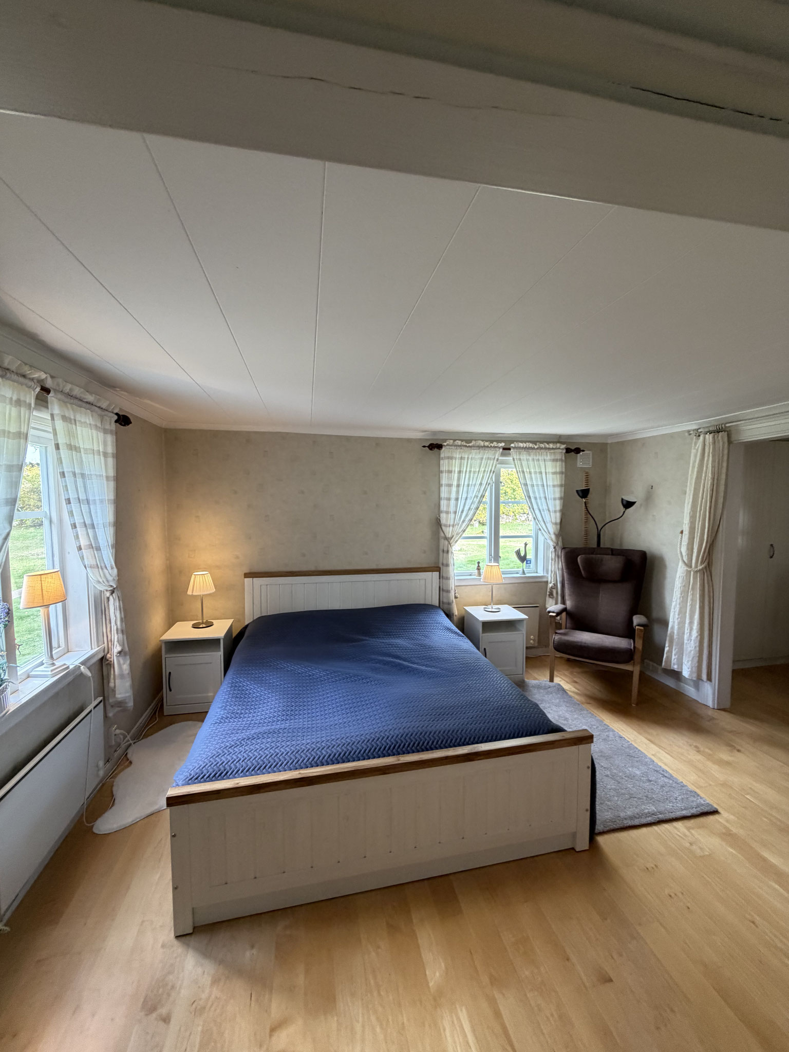 Schlafzimmer 1 im Erdgeschoss mit Doppelbett, Tv und offenem Kamin