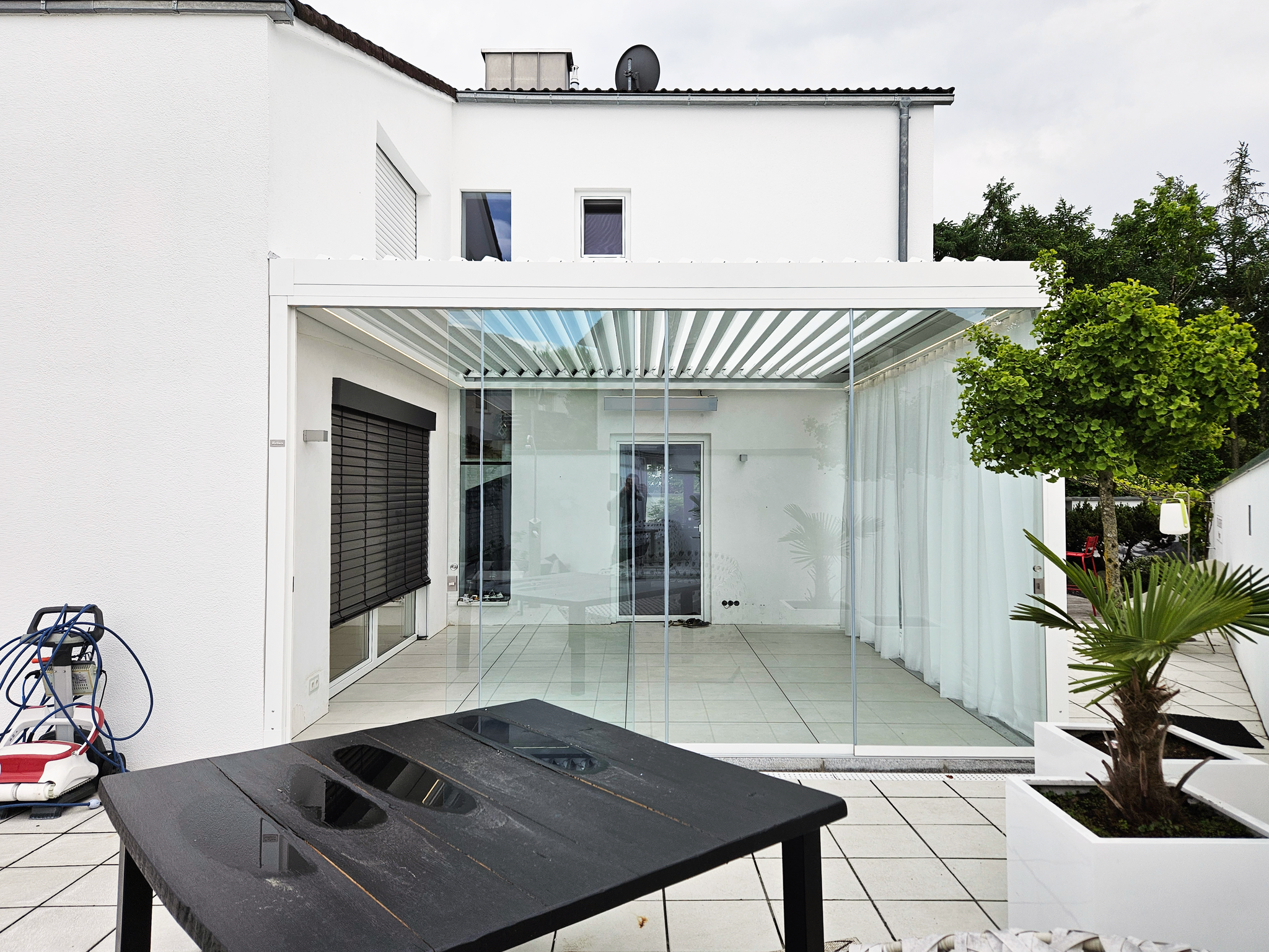 weißes Terrassendach mit Verglasung und Vorhängen in Eggenfelden