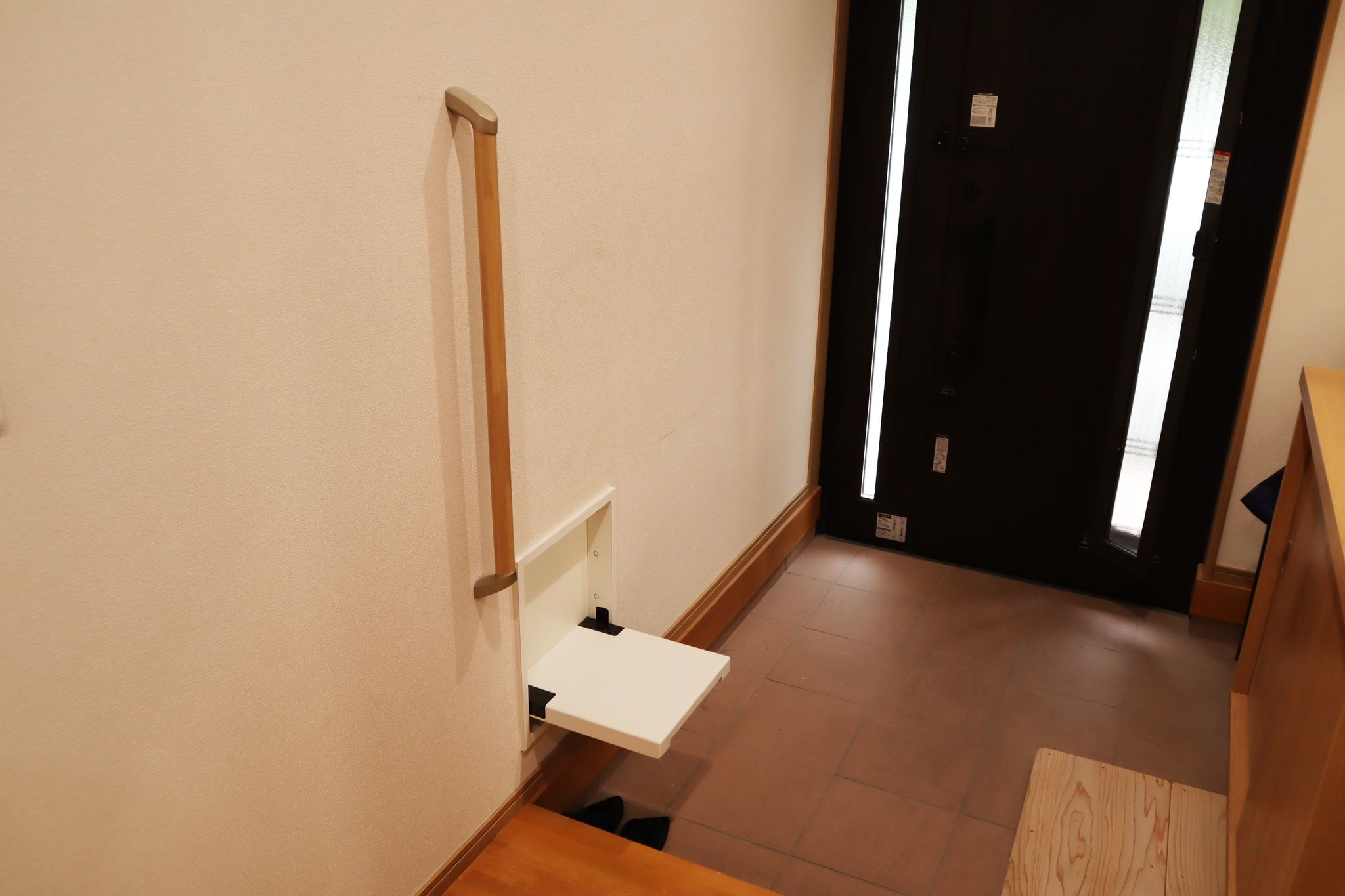 【履き替え用腰掛けと手すり】  お体の不自由なお客様のために 玄関には靴の履き替え時にご利用いただける 腰掛け(収納式)と手すりを設置しております。
