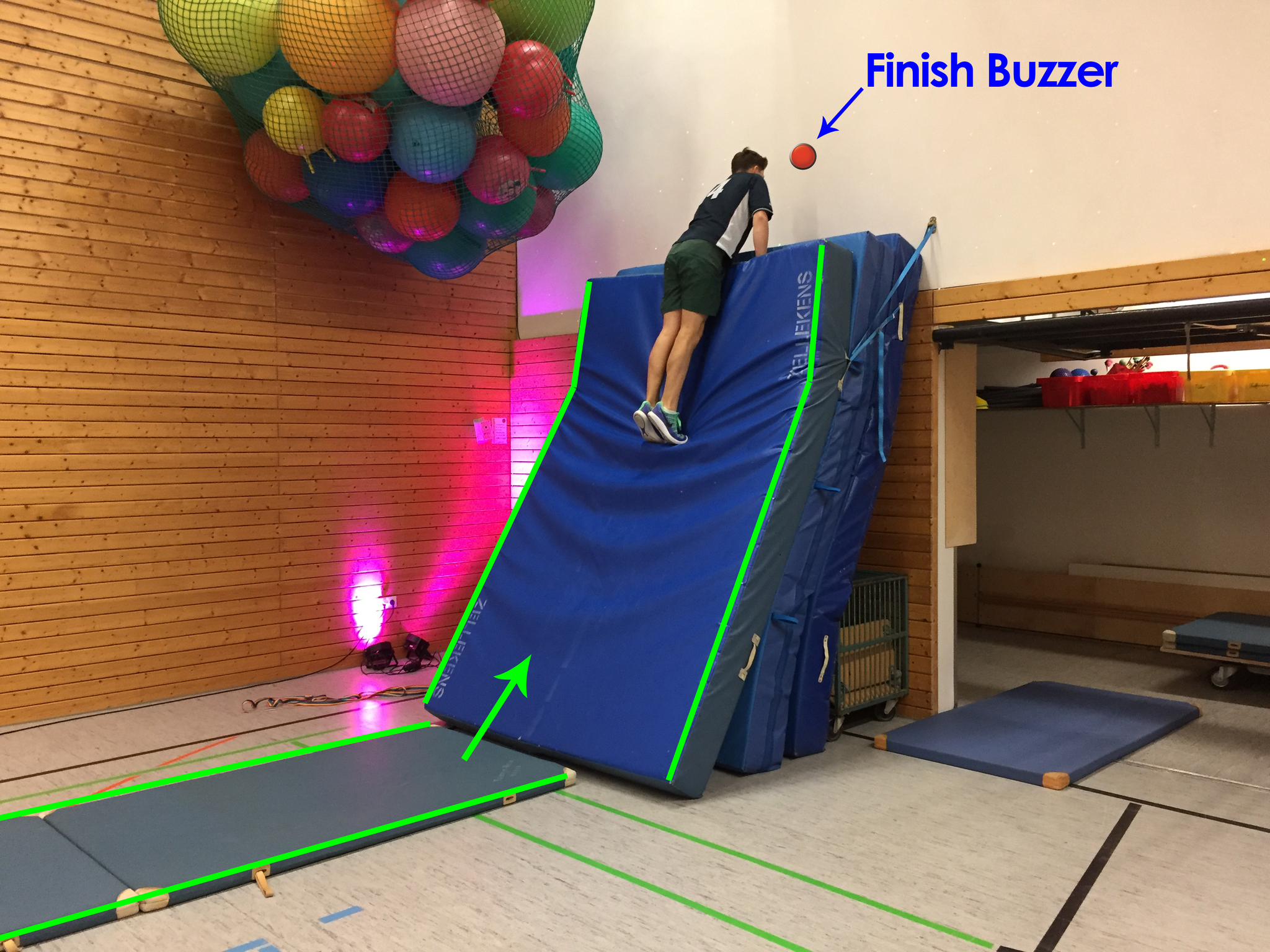 Mit Anlauf die Weichbodenwand hinauf zum Buzzer, um den Parcours vollständig zu beenden.