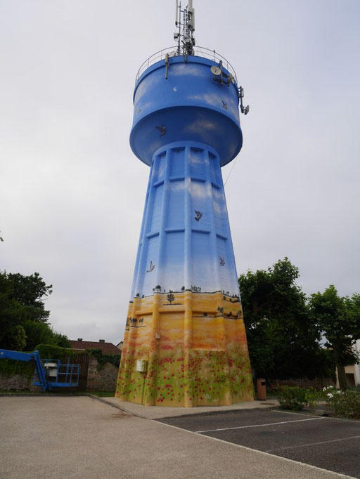 fresque sur le château d'eau de Bouglon par l'artiste Thibaud Coron représentant un paysage, un ciel, envol de d'oiseaux