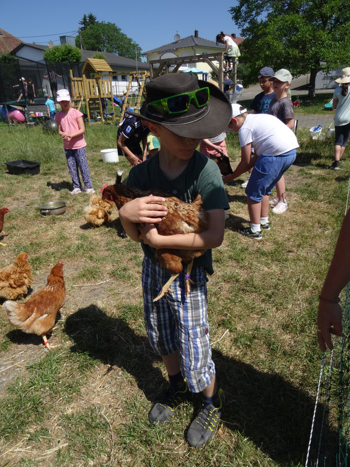 Ein Junge mit einem Huhn auf dem Arm