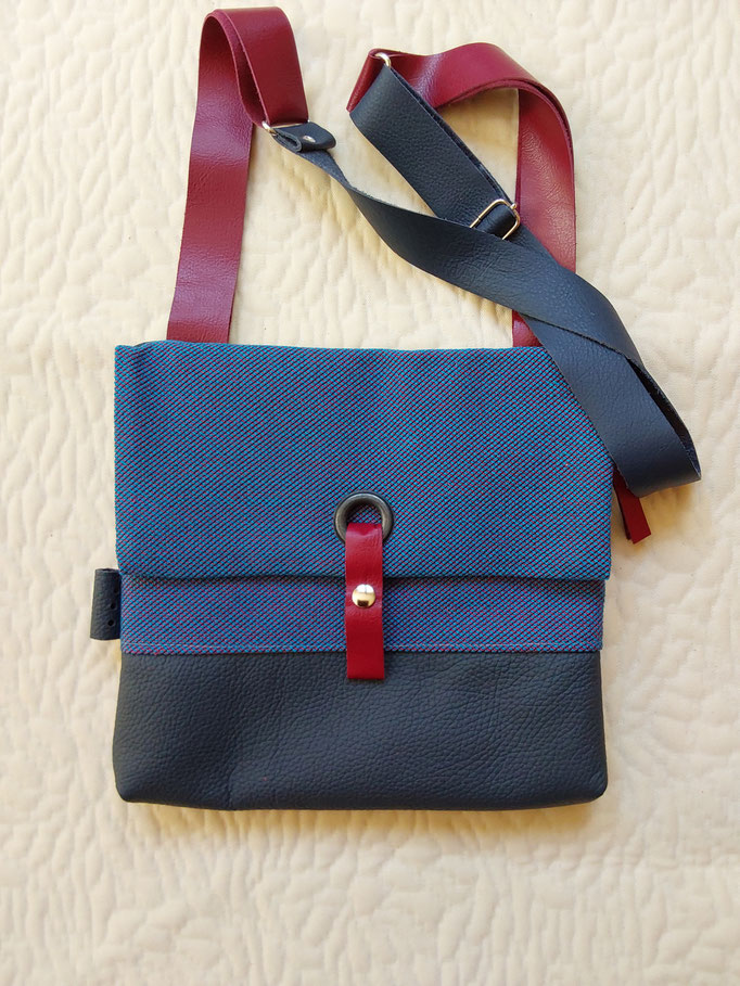 stof/leer (b 26cm x h.25cm) extra voorvak.sluit met rits. verstelbare schouderband.€ 75,--
