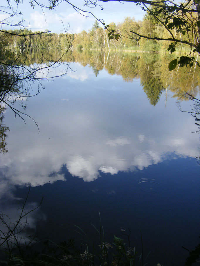 vollkommen ruhiges Wasser spiegelt den Himmel