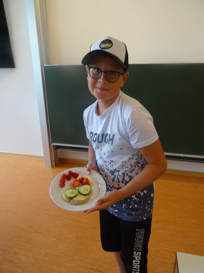 Junge zeigt stolz sein selbst gestaltetes Brotgesicht