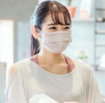 トレーニングで汗をかき、さわやかに笑うマスクをした若い女性