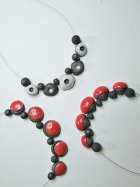 ensemble de colliers en  ceramique raku rouge et blanc simple et chic fait par l atelier simplement terre