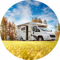 Freunde an Campingtisch vor Wohnmobil 2025