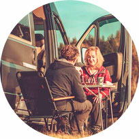 Paar vor Wohnmobil auf klappbaren Campingstühlen 2025