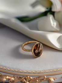 MOKOŠEV luxury jewelry, gold ring with a faceted brown crystal on an elegant light surface.