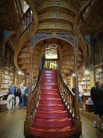 Buchhandlung Lello: Geschnitzte Holztreppe, die sich in zwei Aufgänge verzweigt und in den ersten Stock windet ©My own Travel