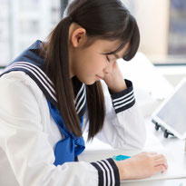 疲れて授業中に教室で眠ってしまう女子中学生