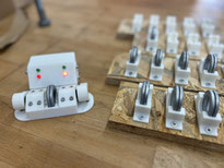 links im Bild eine Prüfvorrichtung, bei der die richtige Orientierung von 2 Unterlegscheiben anhand Tastern und Lichtisgnalen getestet werden kann. Rechts im Bild sind kleine Materialträger, in die die geprüften Unterlegscheiben eingelegt werden können