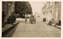 "Changé (Sarthe), rue de l’Église : des soldats américains (GI’s) escortent des prisonniers allemands lors de la Libération."