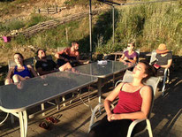 un groupe de stagiaire en repos autour d'une table profitant du soleil avec Juliette ADDESSO lors d'un stage bien être au gite de la Gorre Ardéche