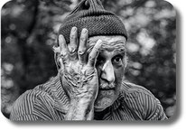 Ein Senior drückt seine Hand an sein Gesicht.