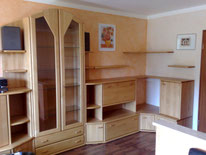 Gestaltung mit Lesando Lehmputz farbig gewachst, Laminatboden.  Wohnzimmerwand mit Metallic-Lasur im kräftigen Rotton beschichtet.