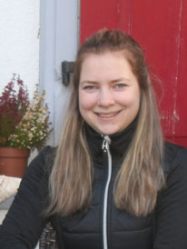 Paula lächelt in die Kamera. Sie hat lange blonde Haare.