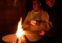 Le feu, allumé par le P. Yves LAOT, transmet la lumière au cierge Pascal (Eglise St Pierre de Pleyber-Christ)