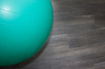 Gymnastikball welcher zu 50 % sichtbar ist, in der türkisenen Farbe, welche am Boden liegt, aber aufgeblasen ist 