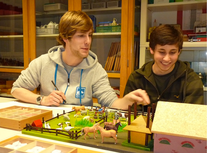 Ein Mitarbeiter des Montessori-Teams Münster mit einem Pädagogik-LK-Schüler einer Besuchergruppe