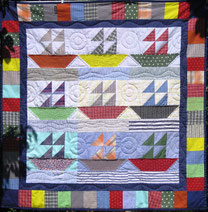 Patchwork-Wandbehang mit Schiffen als Muster.