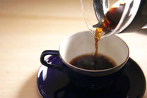 コーヒーカップにコーヒーを注ぎ入れる画像