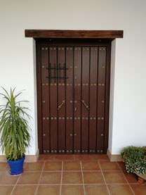 Puerta de aluminio blindada con postigo.