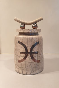 Raku gestookte pot met transparante glazuur en koperkleurige afbeelding.