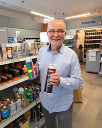 Inhaber Hans-Hermann zwei Spraydosen mit vor Ort gemischten Autolacken in der Handn 