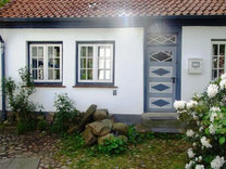 Ansicht des Fischerhauses mit Haustür und zwei Fenstern der Ferienwohnung