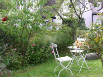 Sitzplatz für unsere Gäste im vorderen Gartenteil, weiße Gartenmöbel aus Holz