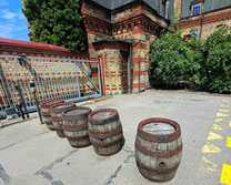 Five historic wooden beer barrels at the entrance to Aldaris brewery in Riga
