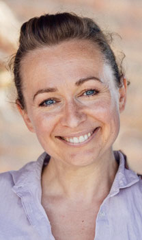Constanze Marienfeld lächelt. Portaitaufnahme. Sie strahlt in die Kamera, das Foto entstand direkt nach einer Trauung.