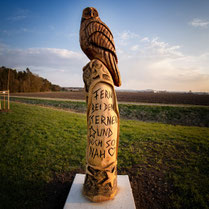 Holzfigur als Silhouette im Sonnenuntergang