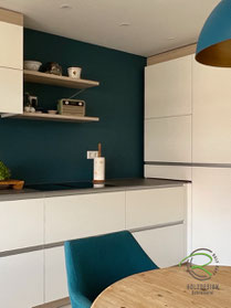 Maßgefertigte Schreinerküche in L-Form in weiß und Eichendekor mit flächenbündigem Muldenlüfter und in der Ecke mit Kaffeenischenschrank mit Drehtüren und ausziehbarem Tablarboden zum Befüllen der Kaffeemaschine