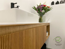 Wandhängender WC-Unterschrank mit 28° Griffleiste in Villingen in Eiche mit Rillendesign, rechts mit offenem, auf Gehrung gefertigten Handtuchfach, weiß durchgefärbter Melaminharz Waschtischplatte und Aufsatzwaschbecken
