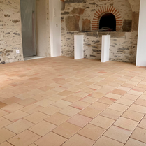 Pose de tomettes dans une pièce de vie moderne et design. Carrelage salon en tomette. Trouver un carrelage qui pose de la tomette autour de moi. Revêtement de sol en tomettes.