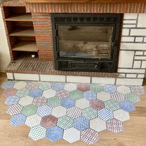 Pose de carreau de ciment devant une cheminée. Carreaux de ciment design et coloré pour pièce de vie. Protéger un parquet devant une cheminée. Carrelage hexagonal carreaux de ciment incrusté.