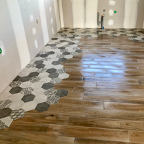 Dernière tendance carrelage pour le sol d'une cuisine, d'un salon, d'une salle à manger. Carreaux de ciment hexagonal incrustés avec carrelage imitation parquet design.