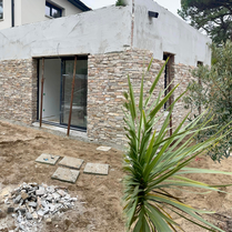 Rénovation de façade design en pierre pour extension. Pierre de parement pour mur extérieur design. Carreleur pour pierre de parement en extérieur. Mur moderne en pierre pour façade. 