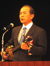 三線を手に講演する大工さん
