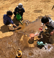 土や水で遊ぶ幼児たち