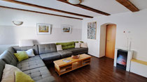 Wohnzimmer mit großer ausziehbarer Couch und Fernseher