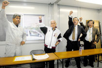 連合沖縄の大城会長(右から2人目)らとともにガンバロー三唱する大浜氏=17日午後、後援会事務所