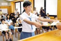 宜野座会長から表彰状を受け取る科学作品展の入賞者=15日午後、市立図書館