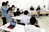 八重山採択協議会からの離脱を表明する竹富町教育委員会の記者会見と、周囲を取り巻く記者たち(11日)