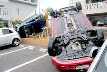 突風で横転した乗用車=13日午前9時ごろ、浜崎町の東横イン石垣島の駐車場