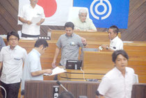 玉津教育長の不信任決議案について無記名投票を行う市議たち=25日、議場